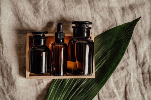 Amber glass skincare bottles in a wooden crate