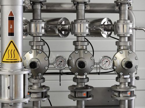 Polished stainless-steel industrial valves and pressure gauges